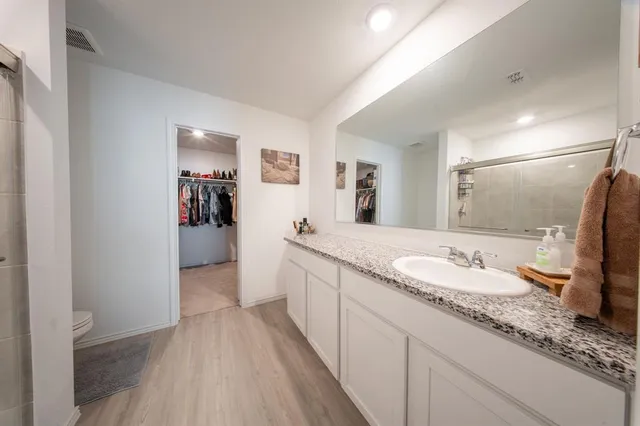 a bathroom with a granite countertop sink and a mirror
