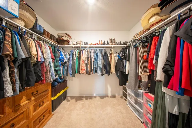 a view of walk in closet with clothes and shoes