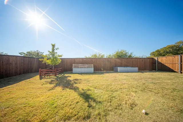 a view of a house with backyard and wooden fence