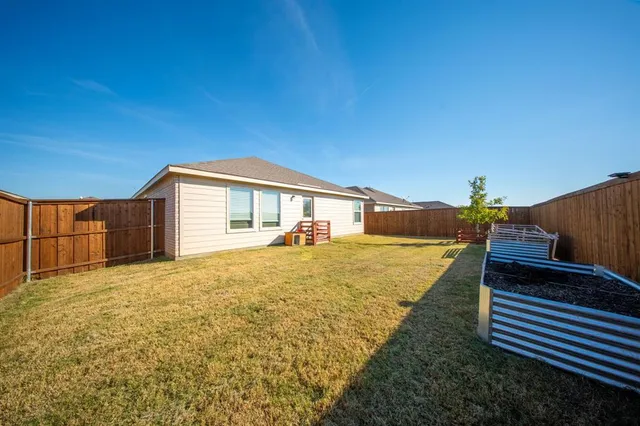 a view of a yard with wooden fence