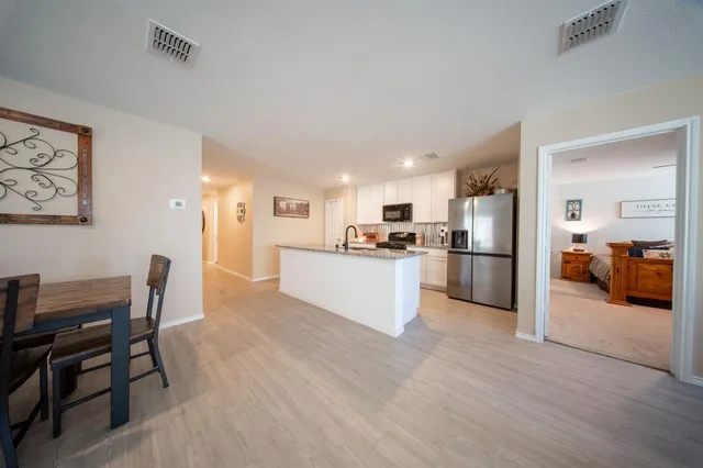 a view of kitchen with refrigerator and wooden floor