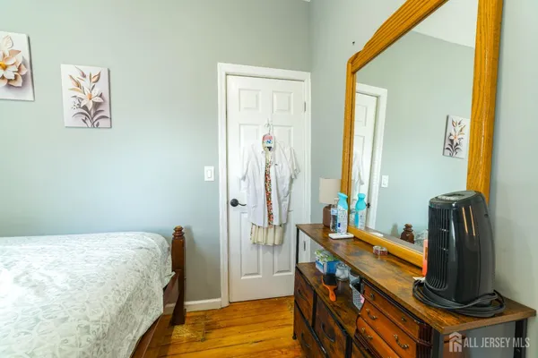 a bedroom with a bed and a flat tv screen on a dresser