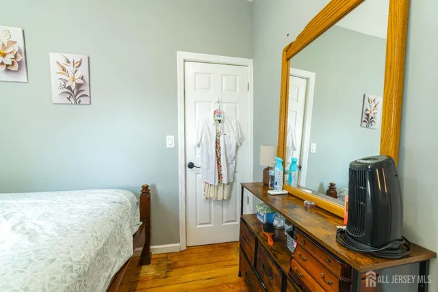 a bedroom with a bed and a flat tv screen on a dresser