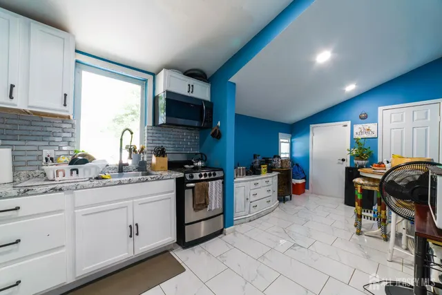 a kitchen with granite countertop a sink stainless steel appliances and cabinets