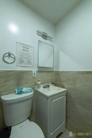a bathroom with a granite countertop toilet a sink and mirror