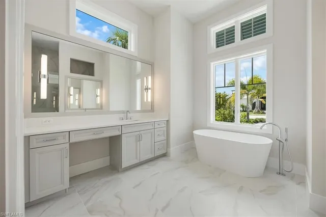 a bathroom with a granite countertop sink mirror and bathtub