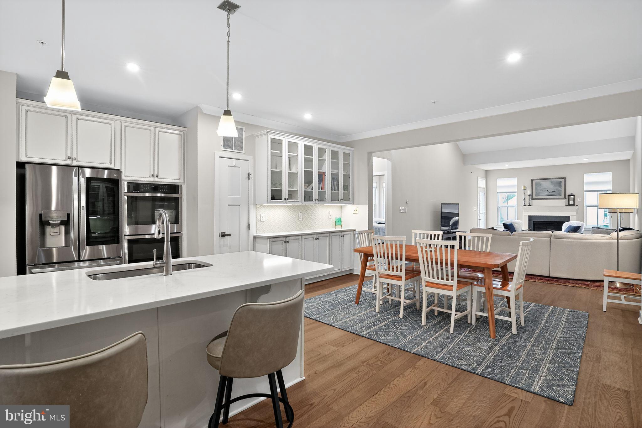 701 Cascade Way Kennett Square, PA 19348 - Photo 12 of 46 a dining room with stainless steel appliances kitchen island granite countertop a dining table chairs and a refrigerator