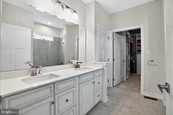 a bathroom with a double vanity sink mirror and shower