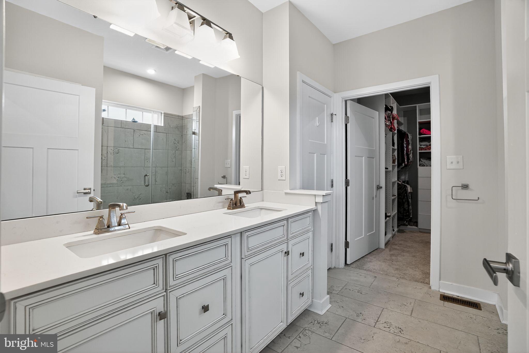 701 Cascade Way Kennett Square, PA 19348 - Photo 25 of 46 a bathroom with a double vanity sink a mirror and a shower