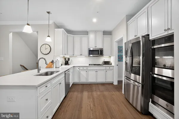a kitchen with white cabinets and stainless steel appliances