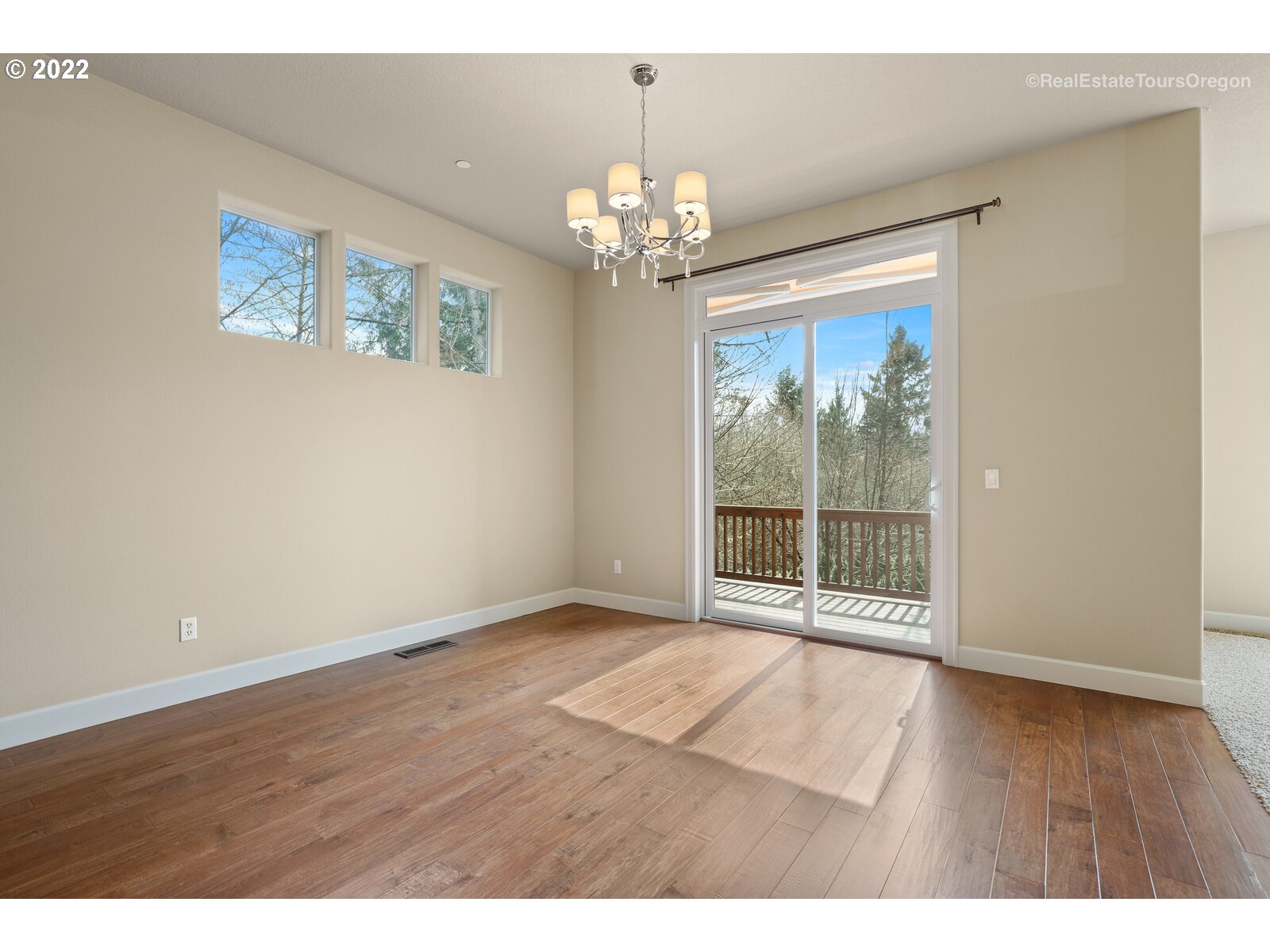 11510 Northwest Knightsview Lane Portland, OR 97229 - Photo 12 of 32 a view of an empty room with wooden floor and a window