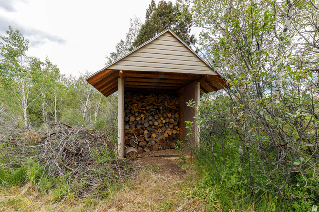 23 Scare Canyon, Unit 23 Logan, UT 84321 - Photo 25 of 33 Dedicated wood storage shed with neutral-toned siding and a pitched roof, surrounded by natural vegetation