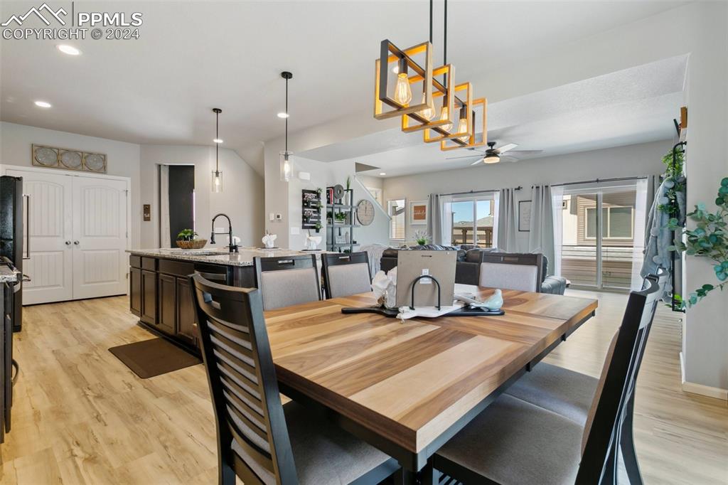 6149 Ashmore Road Colorado Springs, CO 80927 - Photo 13 of 41 a view of a dining room and livingroom with furniture wooden floor a chandelier