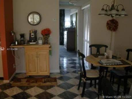195 Fanshaw East, Unit 195 Boca Raton, FL 33434 - Photo 1 of 12 a dining room table chair and a chandelier