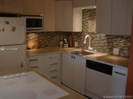 195 Fanshaw East, Unit 195 Boca Raton, FL 33434 - Photo 4 of 12 a kitchen with a sink and a refrigerator