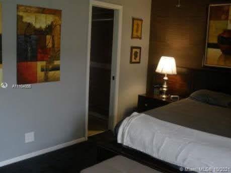 195 Fanshaw East, Unit 195 Boca Raton, FL 33434 - Photo 10 of 12 a bedroom with a bed and a lamp on dresser