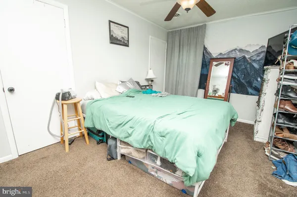 a bed sitting in a bedroom next to a flat tv screen and a chandelier