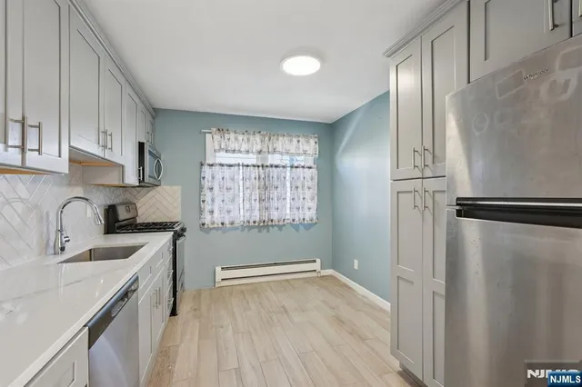 a kitchen with stainless steel appliances granite countertop a refrigerator sink and cabinets