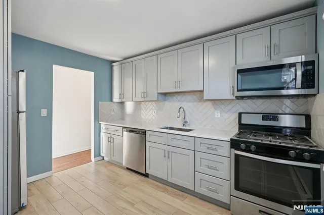 a kitchen with granite countertop cabinets stainless steel appliances and a window