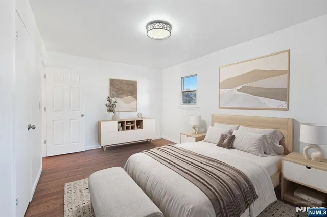 a bedroom with a large bed and a painting on the wall