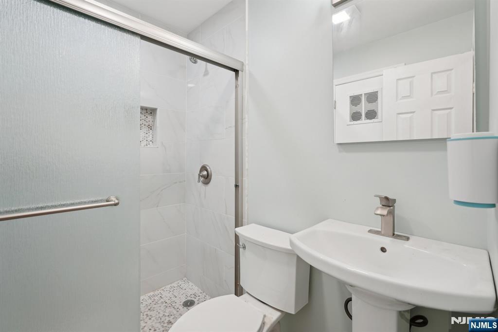 174 Clay Street Hackensack, NJ 07601 - Photo 30 of 33 a bathroom with a sink a toilet and shower