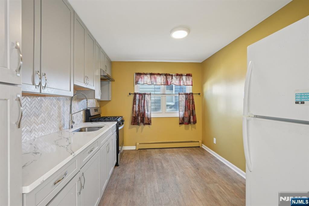 174 Clay Street Hackensack, NJ 07601 - Photo 6 of 33 a kitchen with a sink a stove and refrigerator
