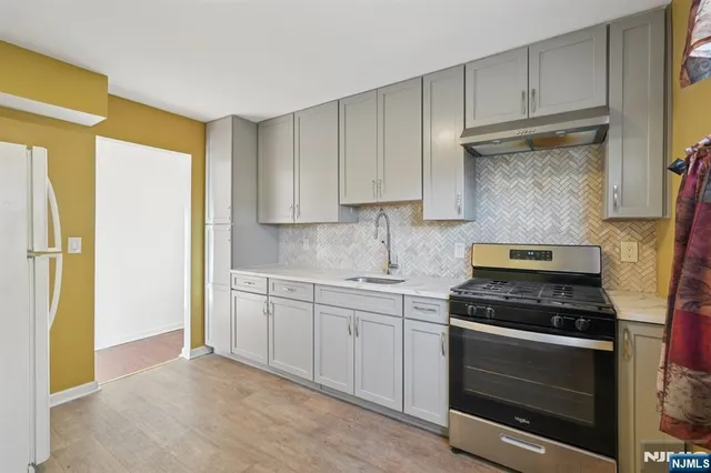 a kitchen with stainless steel appliances white cabinets and a stove top oven