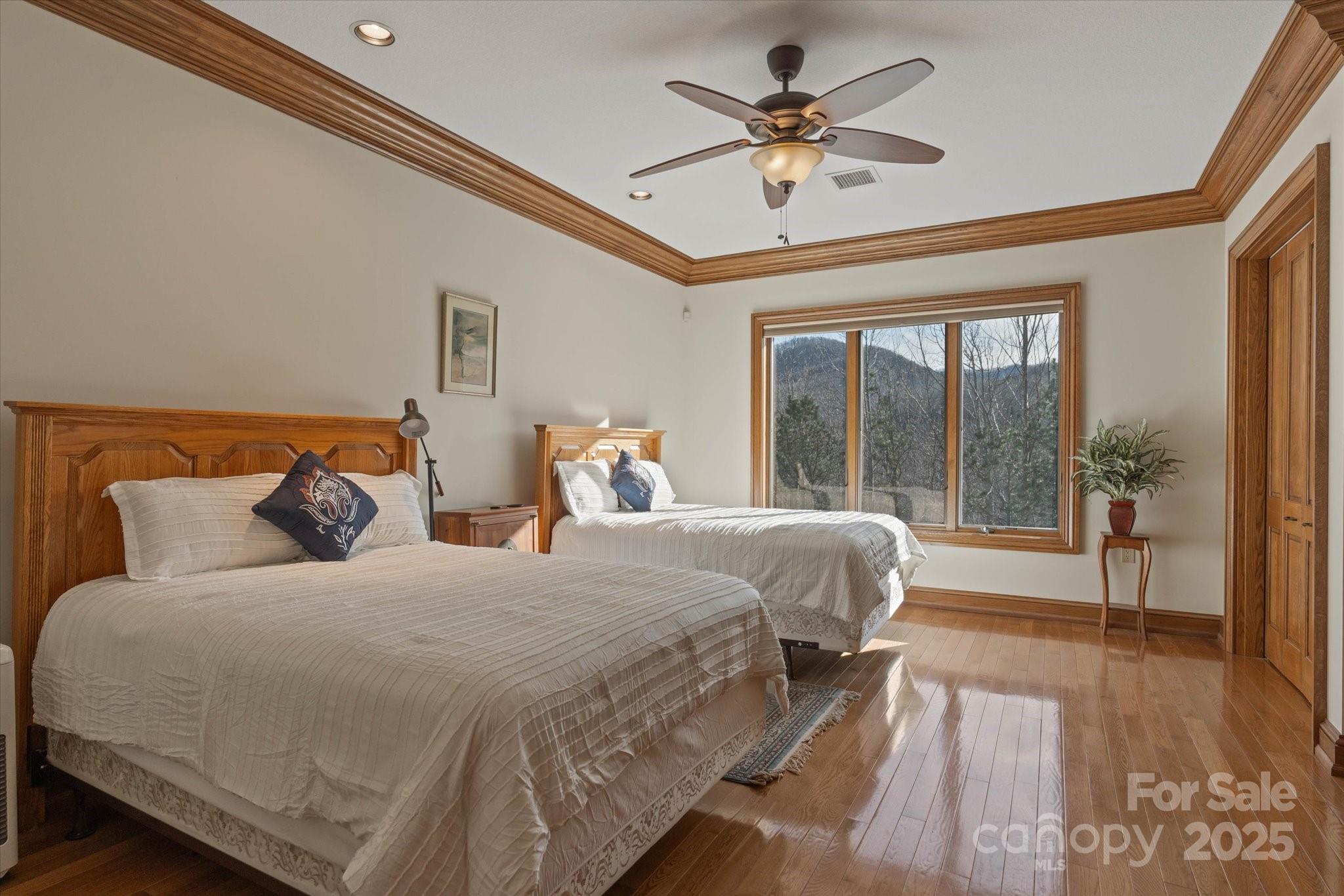 151 Pine Ridge Road Burnsville, NC 28714 - Photo 25 of 48 a bedroom with a large bed and a chandelier