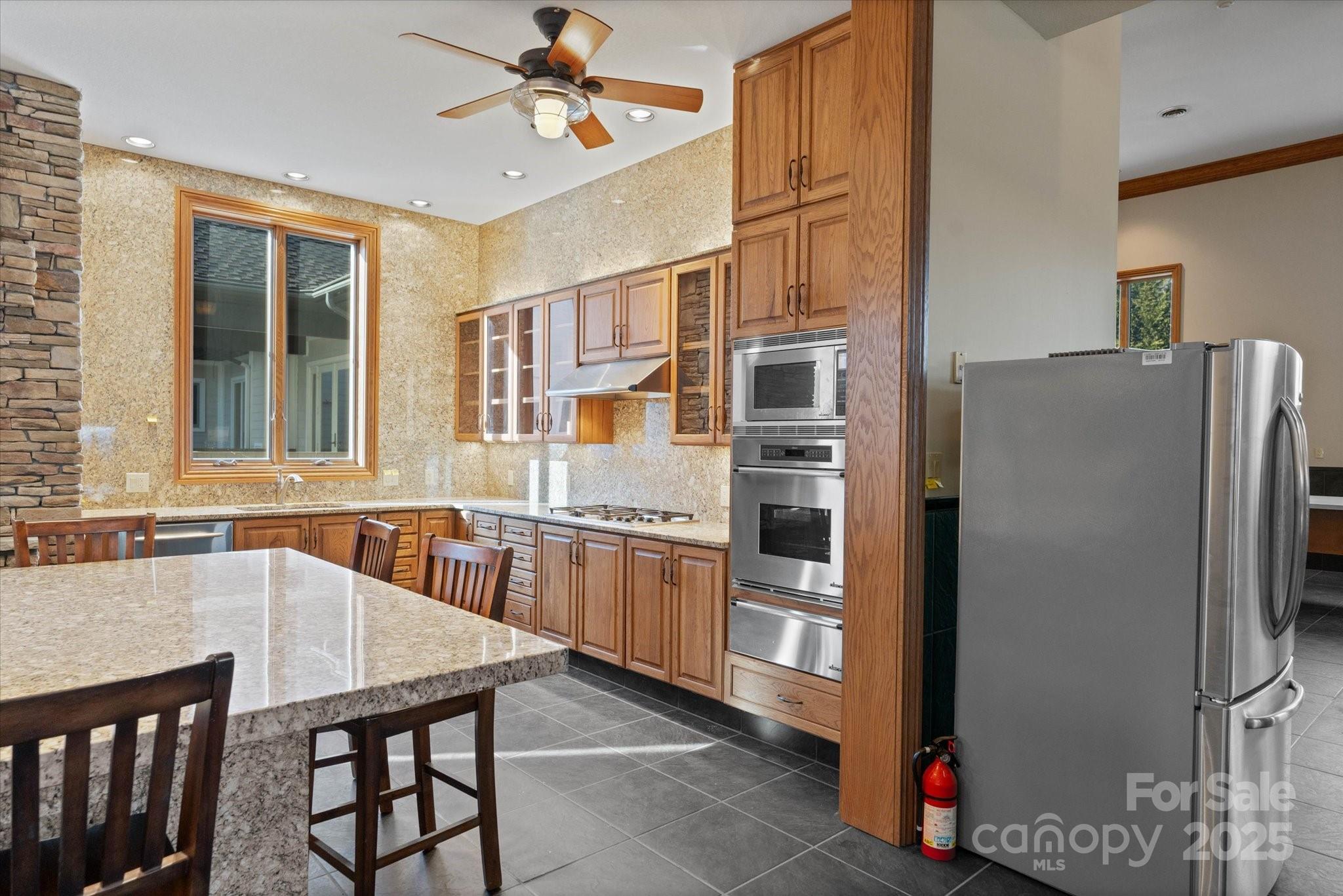 151 Pine Ridge Road Burnsville, NC 28714 - Photo 35 of 48 a kitchen with stainless steel appliances granite countertop a refrigerator a sink a stove and white cabinets