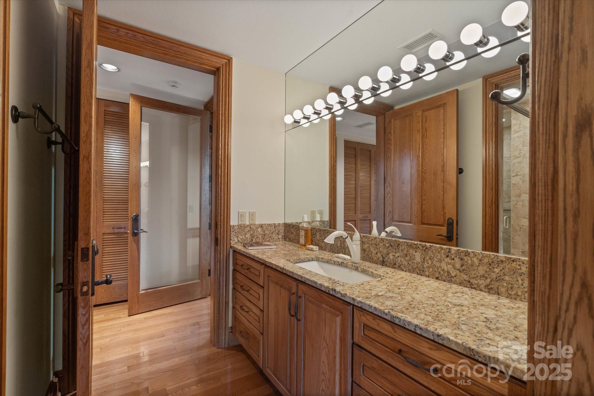 151 Pine Ridge Road Burnsville, NC 28714 - Photo 42 of 48 a bathroom with a granite countertop sink a large mirror and a shower