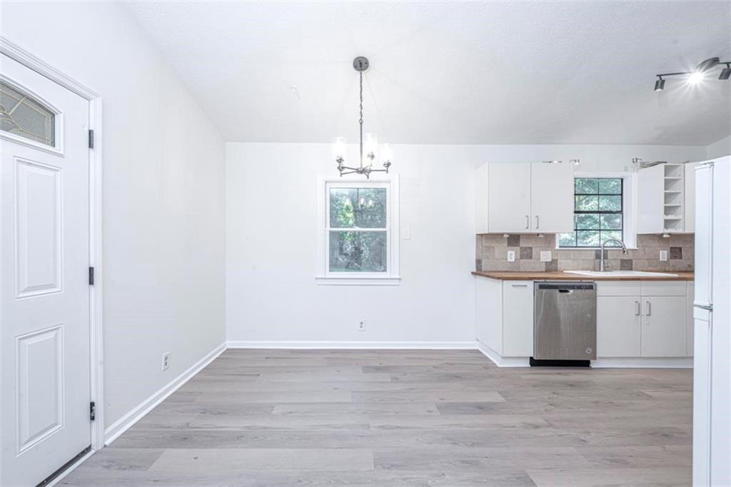 1752 Mitzi Court Duluth, GA 30097 - Photo 28 of 41 a kitchen with granite countertop white cabinets and white appliances