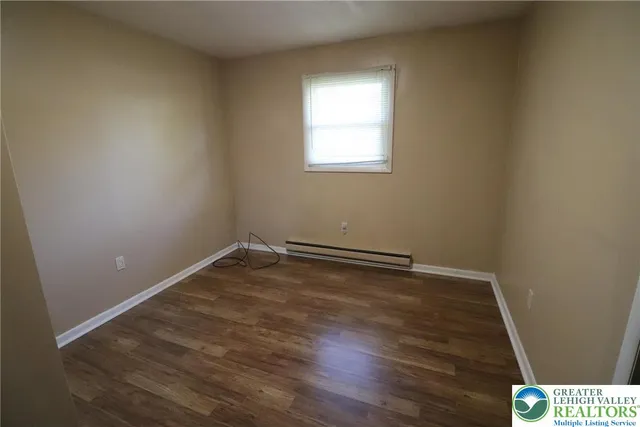 a view of a room with wooden floor and white walls