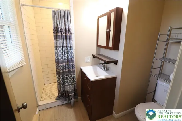 a bathroom with a sink toilet and shower