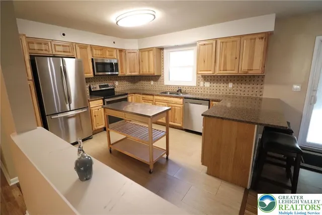 a kitchen with stainless steel appliances a refrigerator stove microwave and sink
