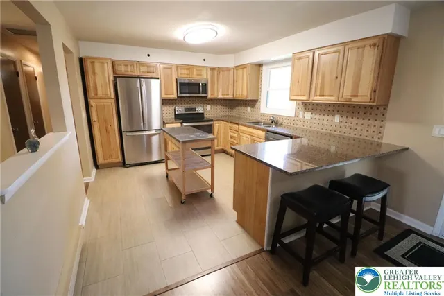 a kitchen with stainless steel appliances granite countertop a refrigerator stove microwave and sink
