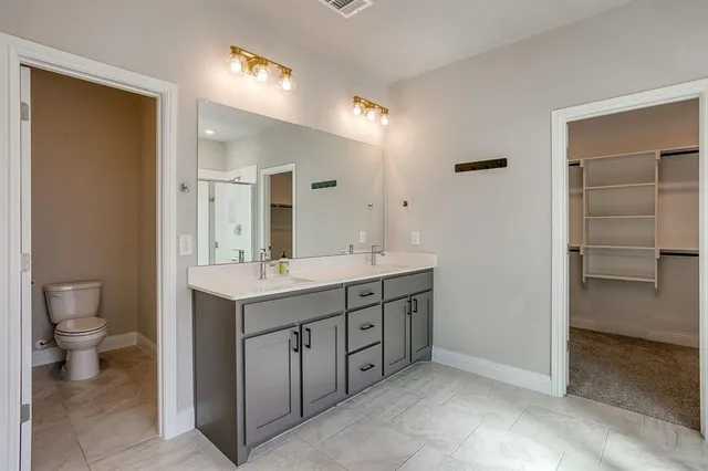 a bathroom with a double vanity sink and a toilet