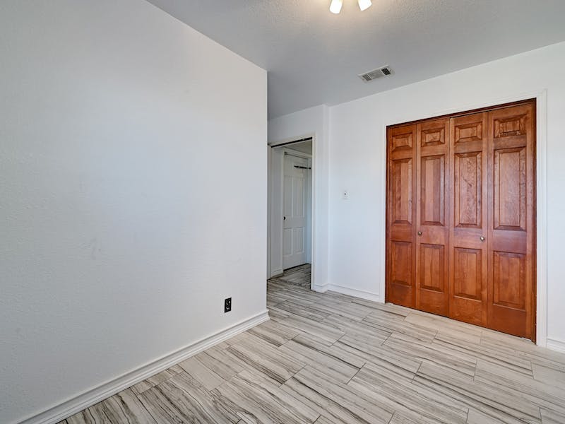 1802 Temple Drive Austin, TX 78721 - Photo 12 of 20 Unfurnished bedroom with a closet and wood finish floors