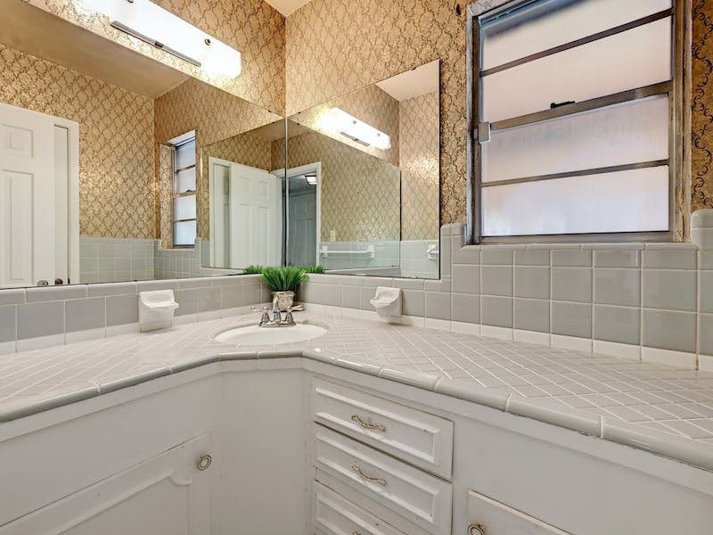 1802 Temple Drive Austin, TX 78721 - Photo 13 of 20 Bathroom featuring wallpapered walls, vanity, and tasteful backsplash