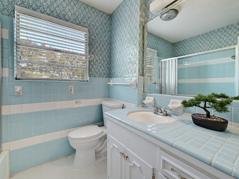 1802 Temple Drive Austin, TX 78721 - Photo 18 of 20 Bathroom with a stall shower, light tile patterned flooring, vanity, wallpapered walls, and tile walls