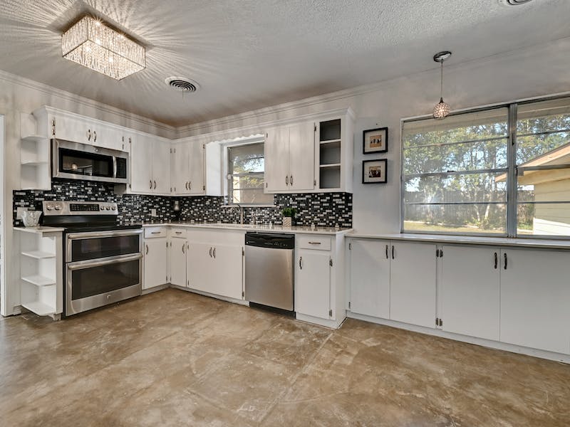1802 Temple Drive Austin, TX 78721 - Photo 7 of 20 Kitchen featuring open shelves, stainless steel appliances, white cabinetry, decorative light fixtures, and a textured ceiling