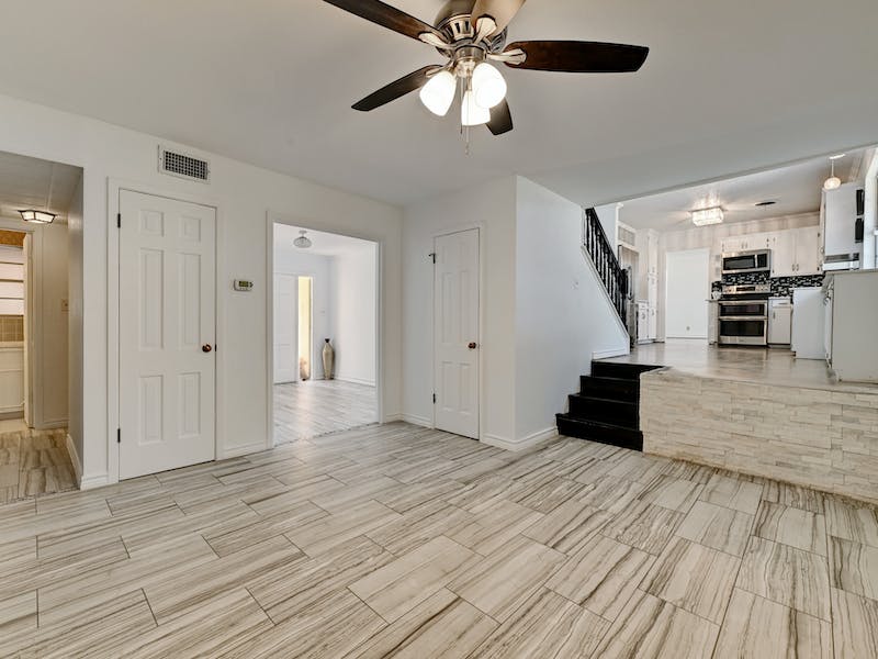1802 Temple Drive Austin, TX 78721 - Photo 9 of 20 Unfurnished living room with ceiling fan, stairs, and wood finish floors