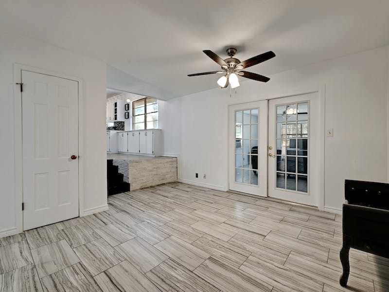 1802 Temple Drive Austin, TX 78721 - Photo 10 of 20 Unfurnished dining area featuring french doors, ceiling fan, and wood tiled floors