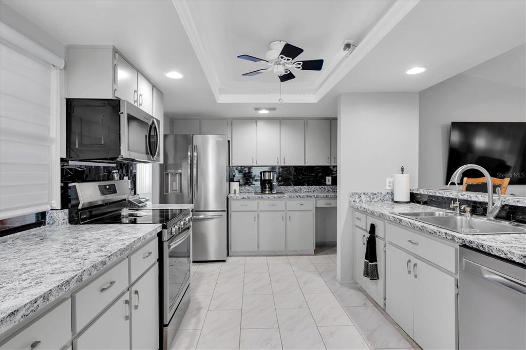 7099 Pond View Court Spring Hill, FL 34606 - Photo 11 of 64 a kitchen with a sink stainless steel appliances and cabinets