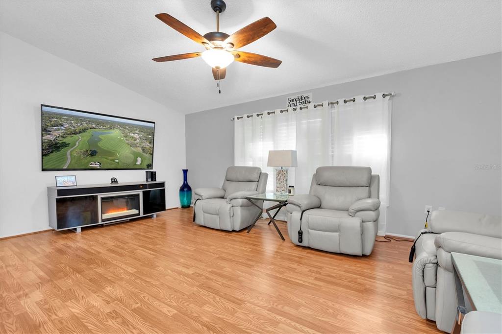 7099 Pond View Court Spring Hill, FL 34606 - Photo 20 of 64 a living room with furniture and a flat screen tv