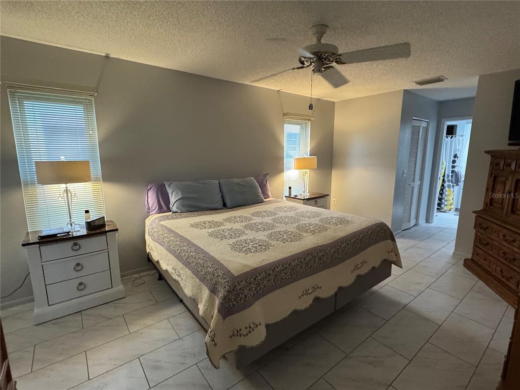 7099 Pond View Court Spring Hill, FL 34606 - Photo 23 of 64 a bedroom with a bed and a chandelier