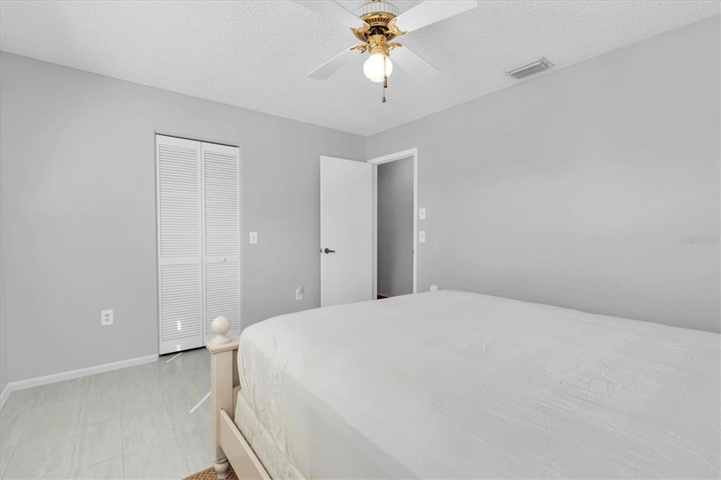7099 Pond View Court Spring Hill, FL 34606 - Photo 28 of 64 a bedroom with a bed and a chandelier