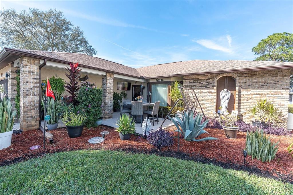 7099 Pond View Court Spring Hill, FL 34606 - Photo 4 of 64 a view of a patio with table and chairs potted plants and palm tree