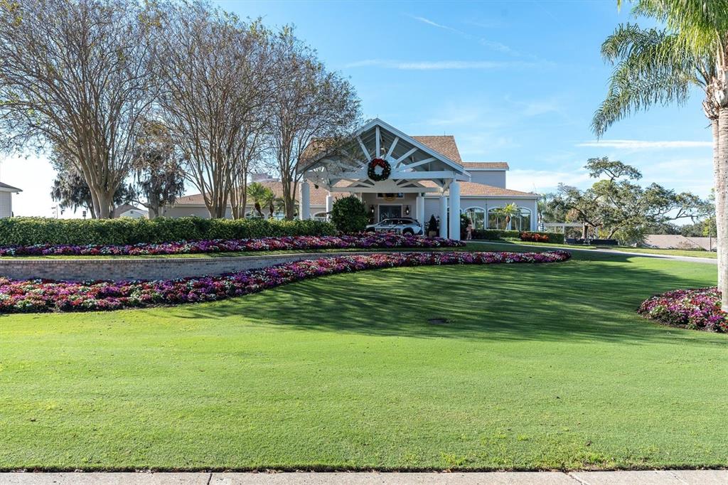 7099 Pond View Court Spring Hill, FL 34606 - Photo 43 of 64 a front view of a house with a big yard and potted plants