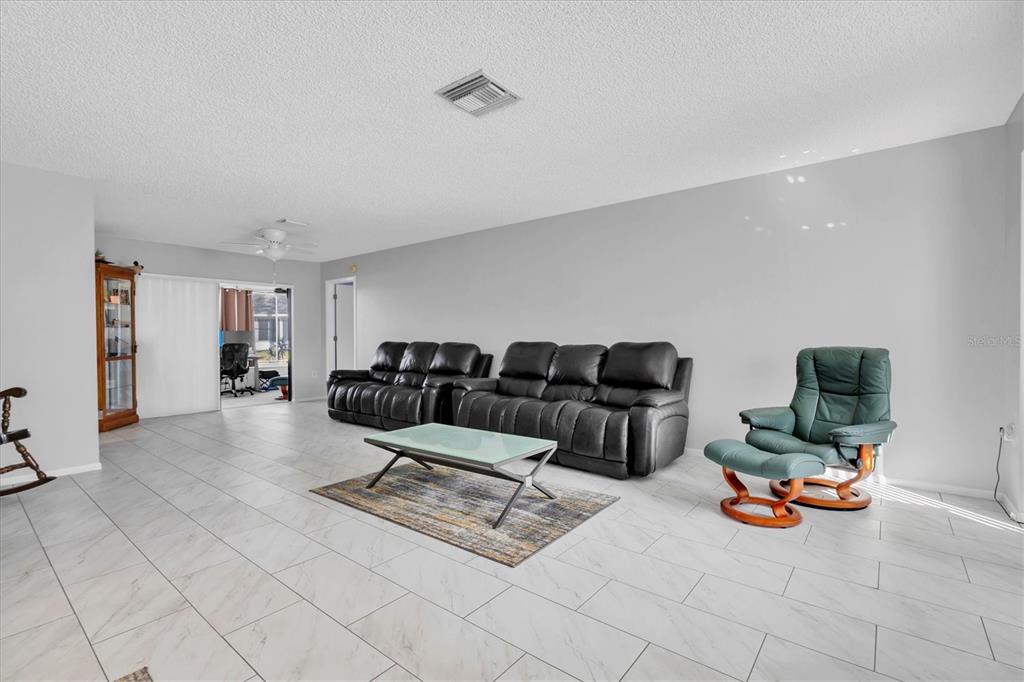 7099 Pond View Court Spring Hill, FL 34606 - Photo 8 of 64 a living room with furniture and a table