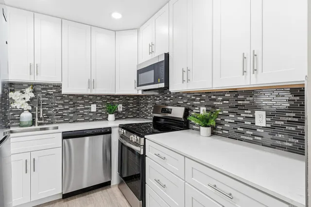 a kitchen with white cabinets and white appliances